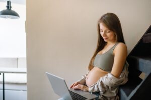 Pregnant professional woman working on laptop — maternity leave rights in India 2026