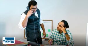 Contract Staffing India: How It Works for Employers - two male colleagues collaborating in office, one talking on phone