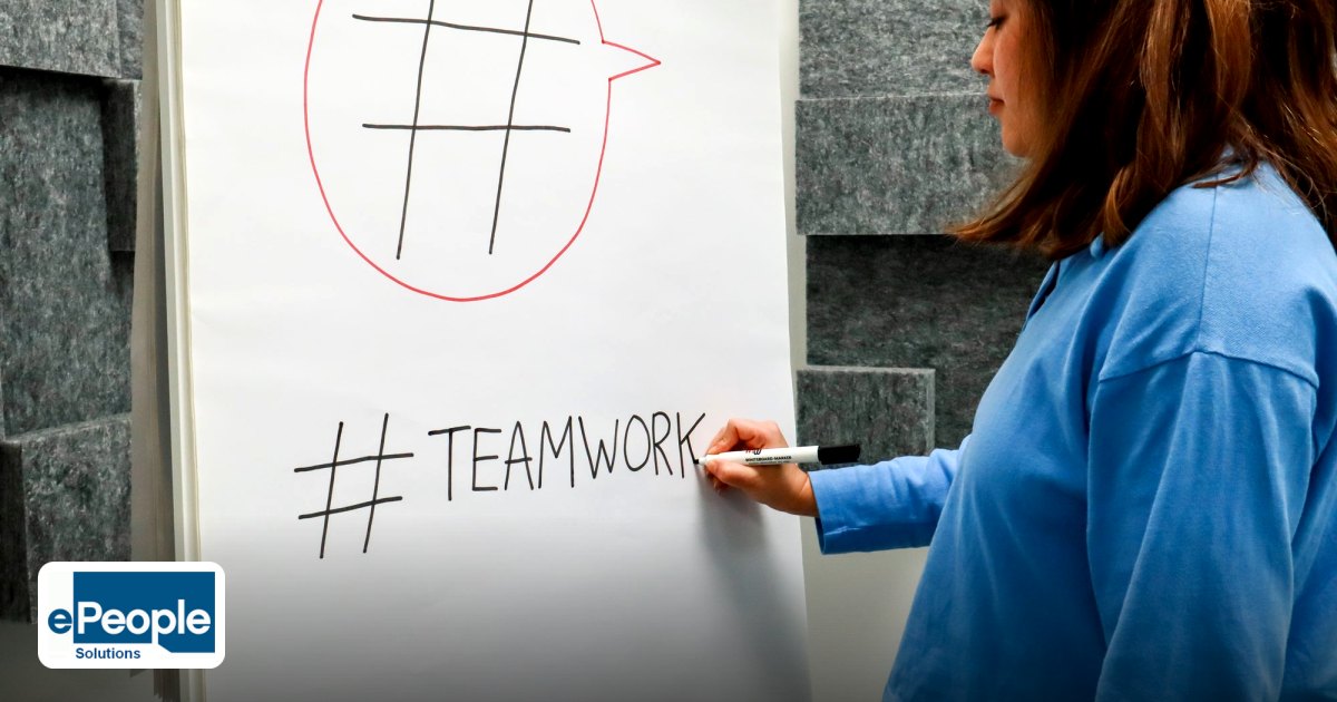 designing-a-hybrid-learning-curriculum-for-indian-hr-teams - a woman in a jean jacket writes "#" on a flipchart during